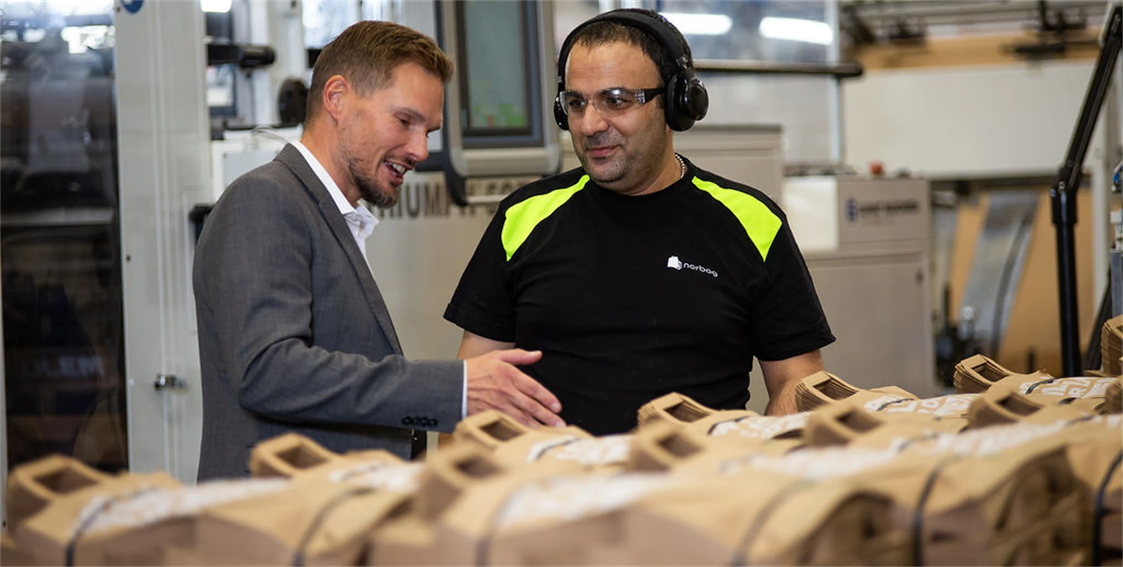 Bild på Torbjörn Rodhe, vd, i samtal med maskinoperatören Issam Ibrahim i Töcksfors.