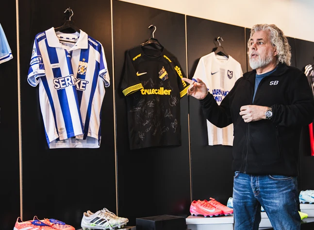 Foto på Brandtowns vd Stephan Burman som visar ett urval av matchtröjor.