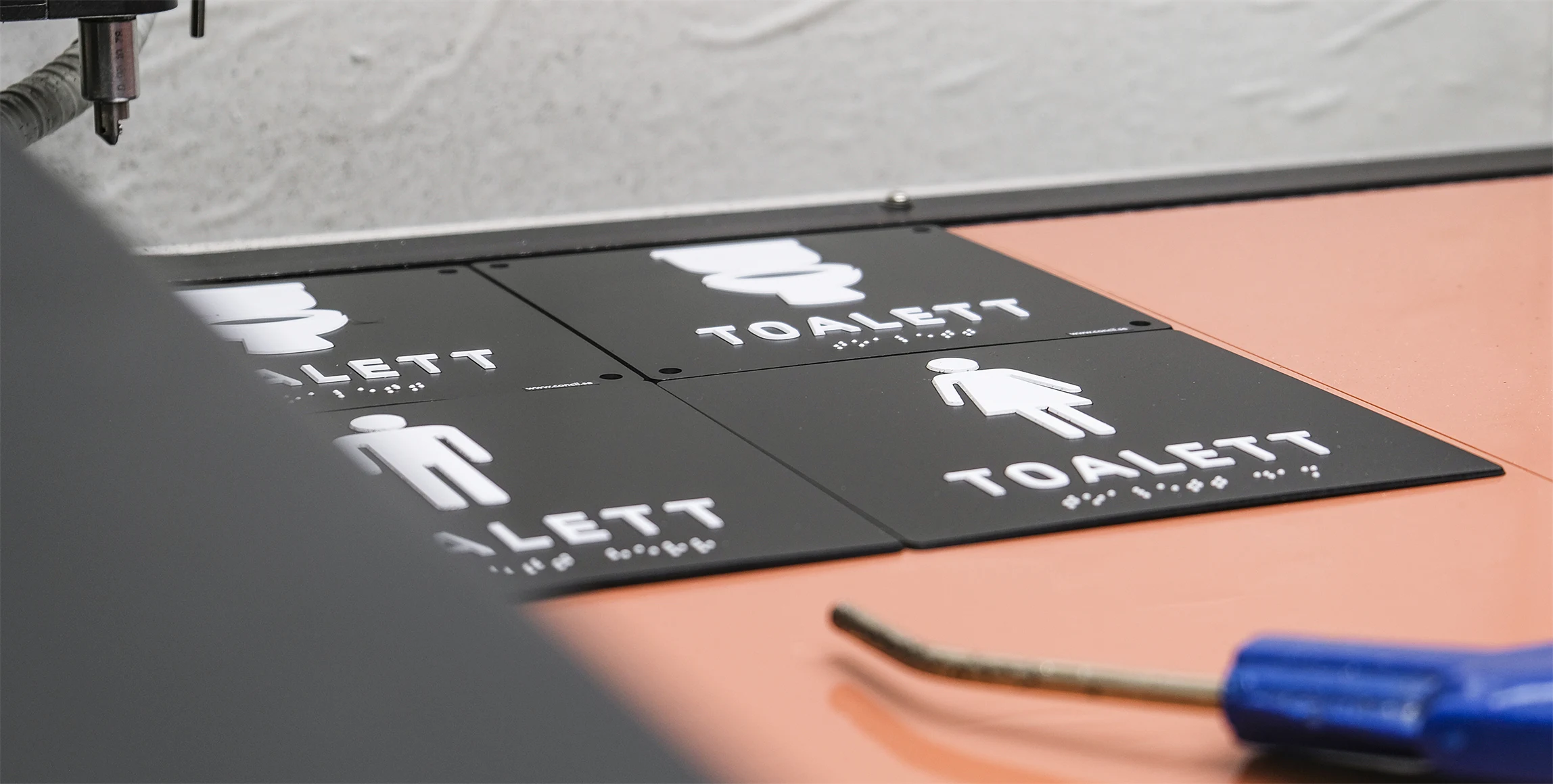 Bild på taktila toalettskyltar.
