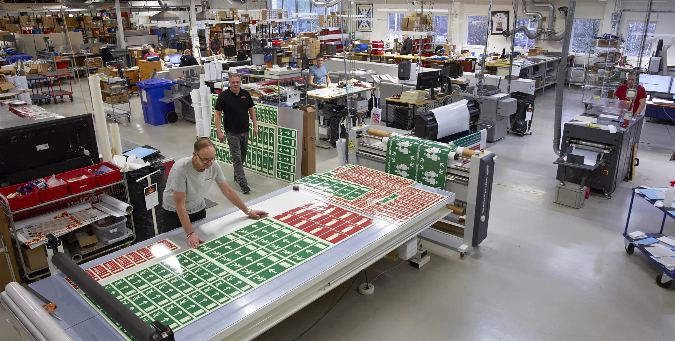 Bild från digitaltrycksavdelningen, med digitaltryckaren Christian Thuresson vid skärbordet.