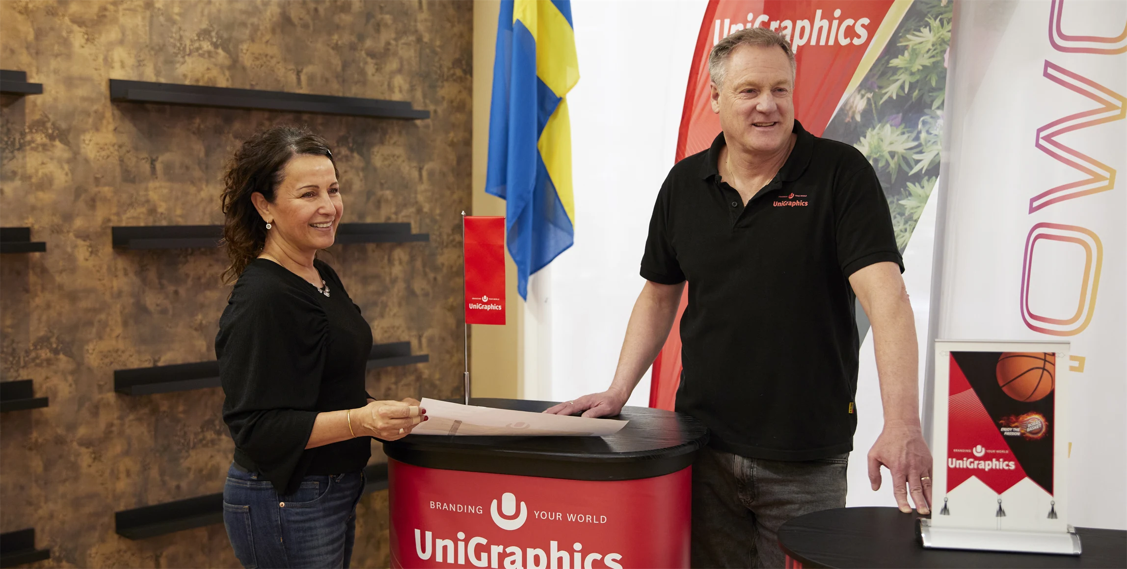 Bild på marknadskoordinator Elena Scilaris och vd Torbjörn Sund i UniGraphics showroom, där företaget visar upp sina produkter för kunder. 