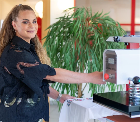 Bild på Alice Norheim, vd på Perma Press, vid en värmepress.