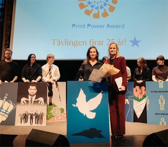 Bild på Johanna Lindgren, vinnare av PrintPower Award 2026, och Eva Glückman, vd Grafiska Företagen, med de andra finalisterna i bakgrunden.